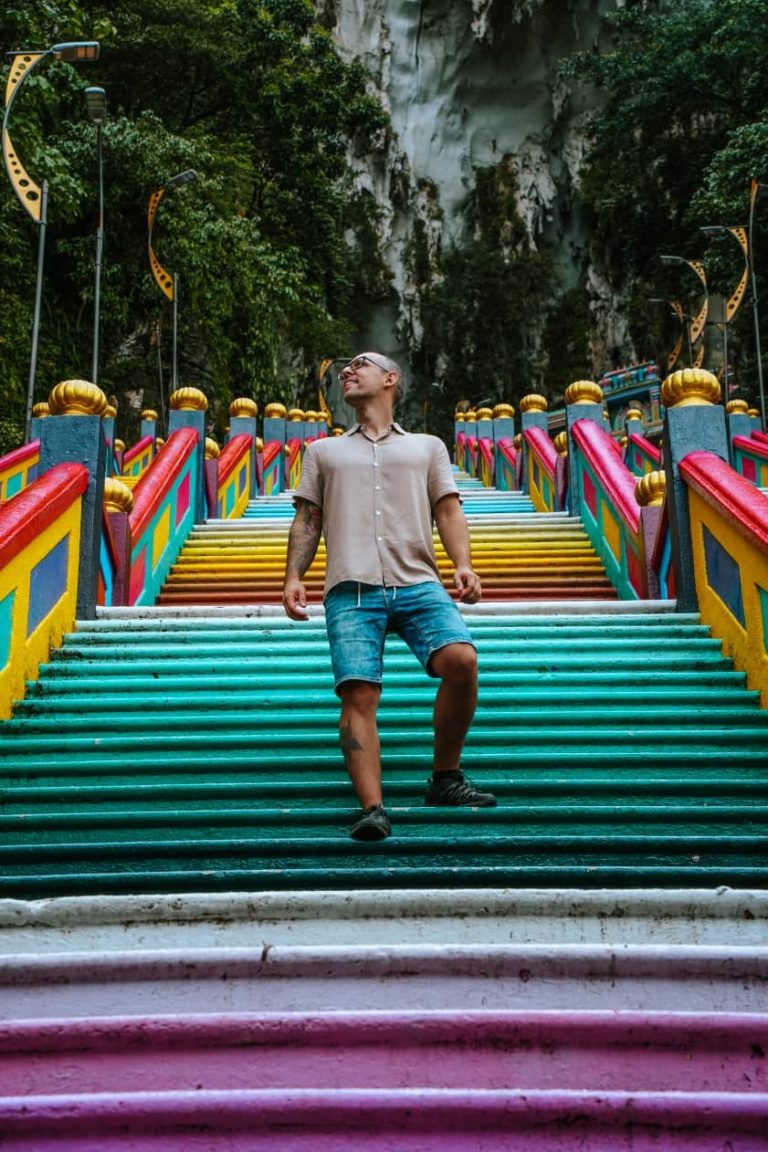 Homem a descer as escadas arco-íris das Grutas de Batu, em Kuala Lumpur, na Malásia.