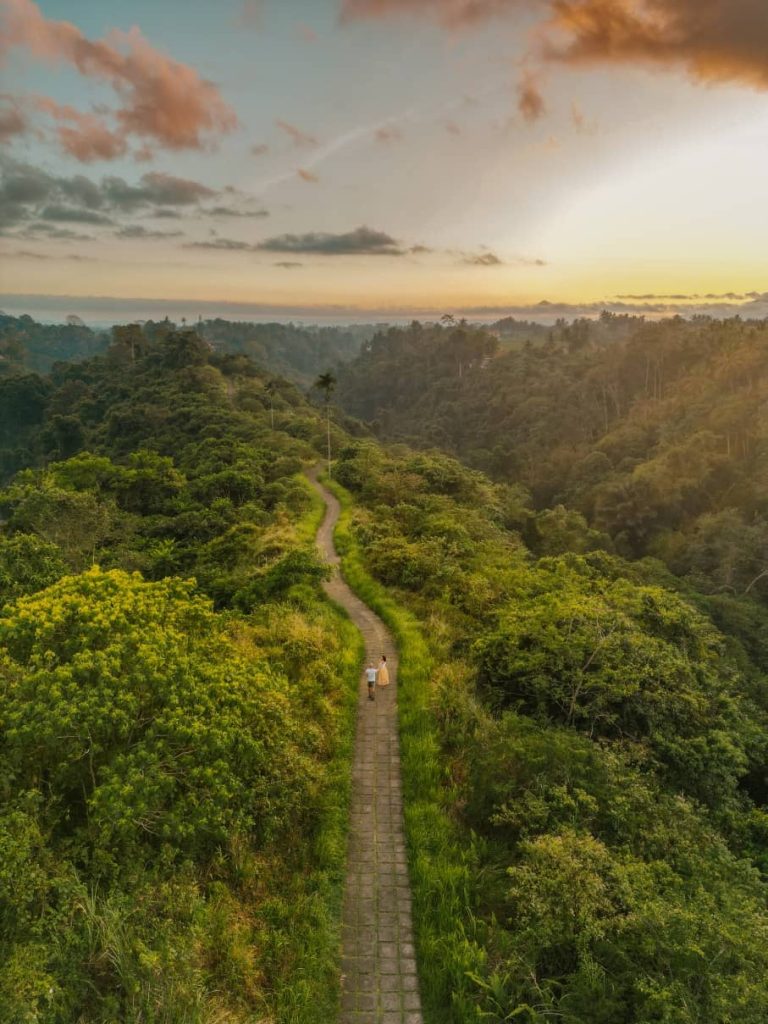 Couple walking down Campuhan Ridge Walk in Ubud at sunrise.