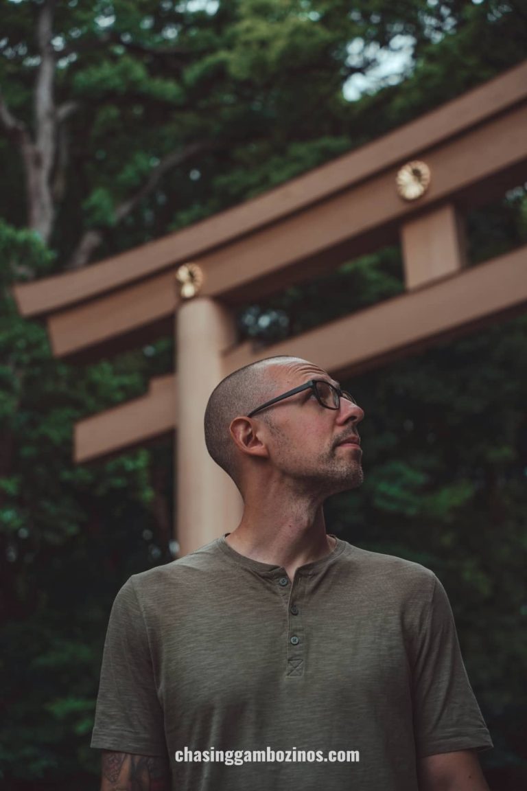 Man in front of Torii Gate at Meiji Shrine entrance.