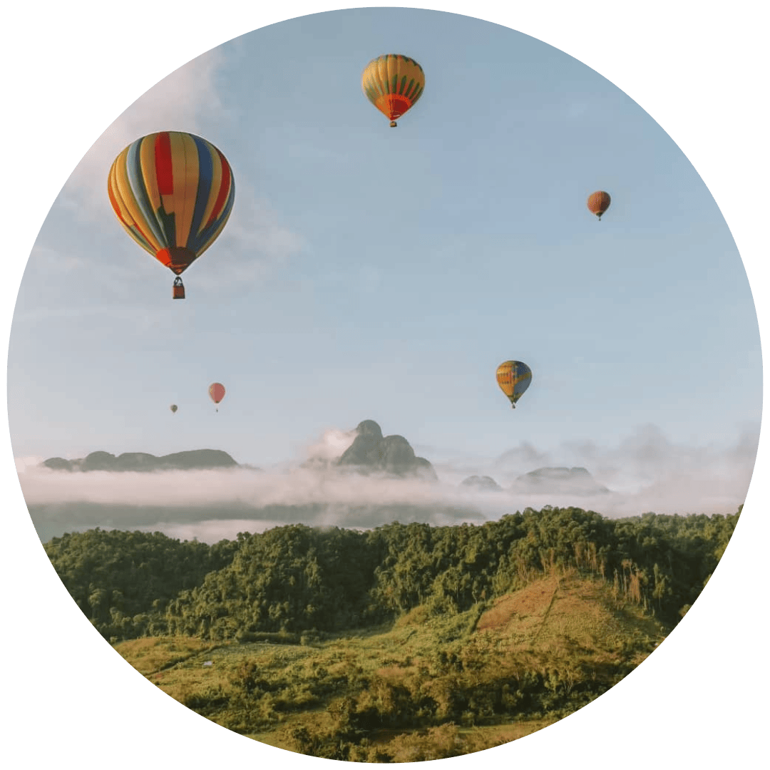 Balões de ar quente a voar ao nascer do sol sobre as montanhas de Vang Vieng, no Laos.