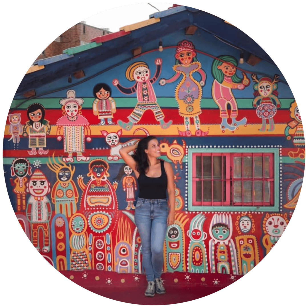 Mulher sorridente perto de uma das casas da Rainbow Village em Taichung, Taiwan.
