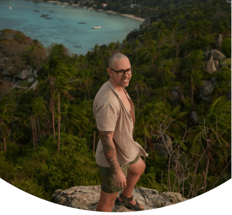 Man smiling on top of John Suwan Viewpoint, one of the most famous Koh Tao viewpoints.
