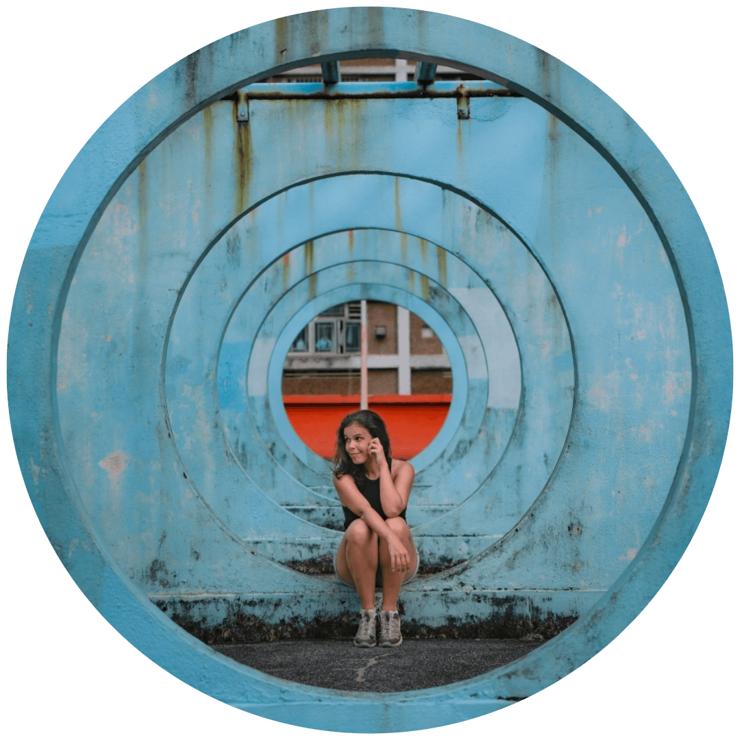 Mulher sentada numa área de recreio circular azul em Hong Kong. Um dos locais mais famosos do Instagram em Hong Kong.