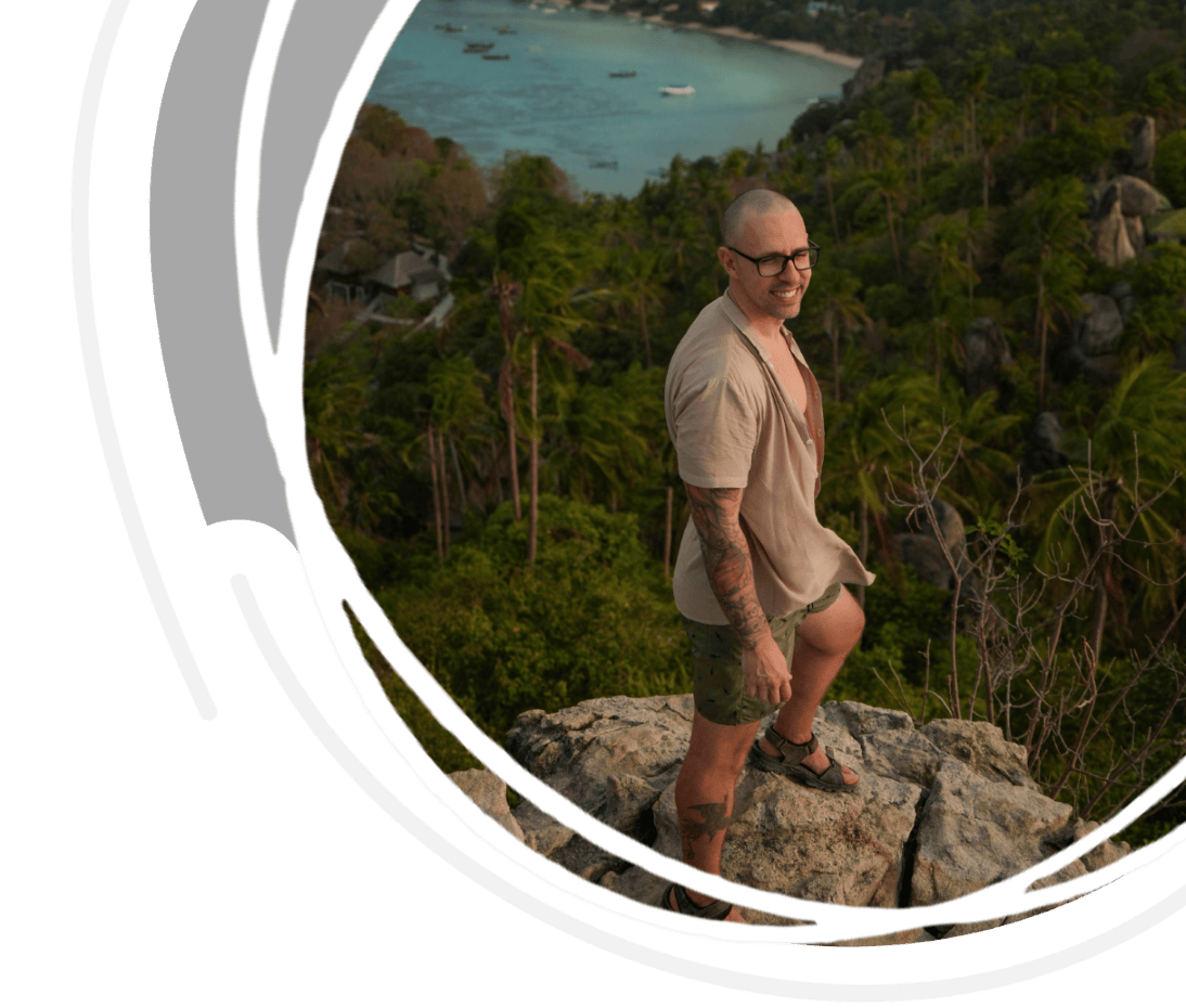 Man smiling on top of John Suwan Viewpoint, one of the most famous Koh Tao viewpoints. Cover for the blog post best koh tao viewpoints.