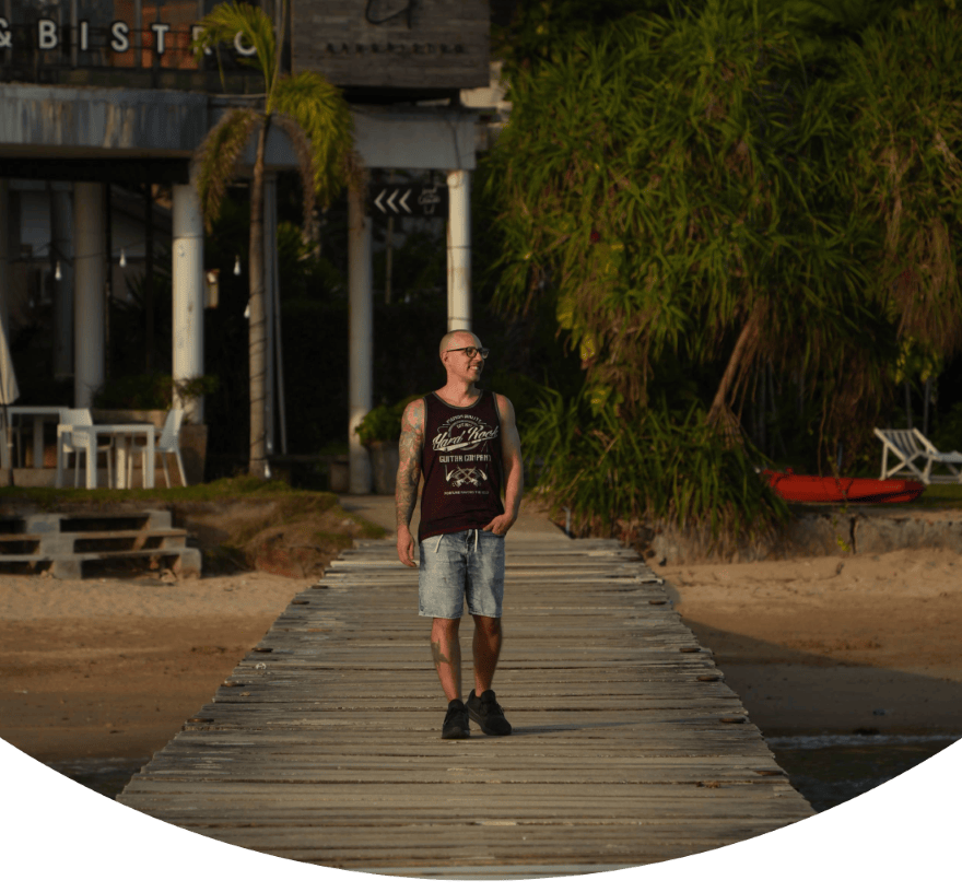Capa de um guia de Koh Mak com um homem a caminhar pelo cais de Ao Kao Beach.