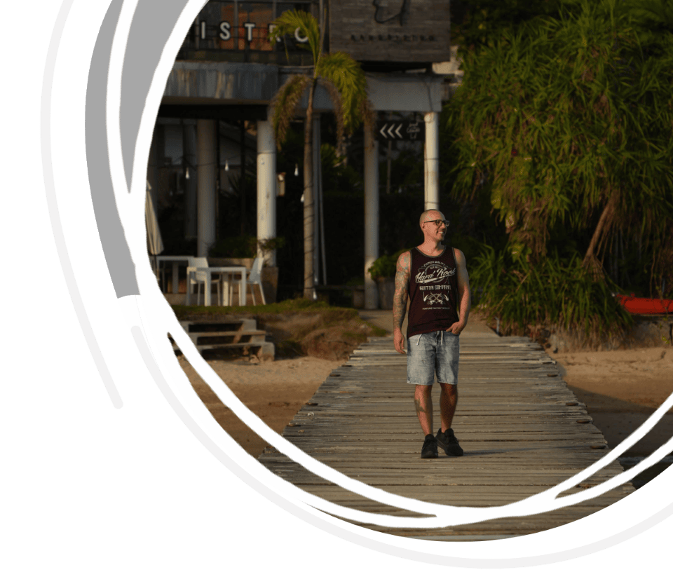 Capa de um guia de Koh Mak com um homem a caminhar pelo cais de Ao Kao Beach.