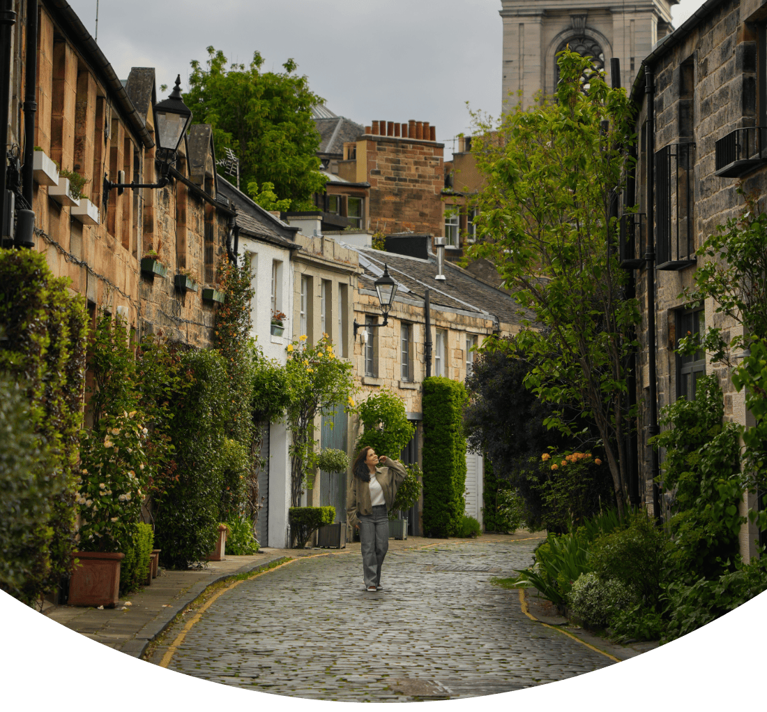Capa do guia de viagem “O Que Fazer em Edimburgo em 3 Dias”, dos Chasing Gambozinos, com uma mulher a caminhar por Circus Lane, em Edimburgo.