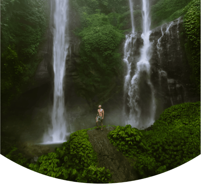 Cover of Sekumpul Waterfall travel blog, featuring a man standing in Sekumpul Waterfall Bali.