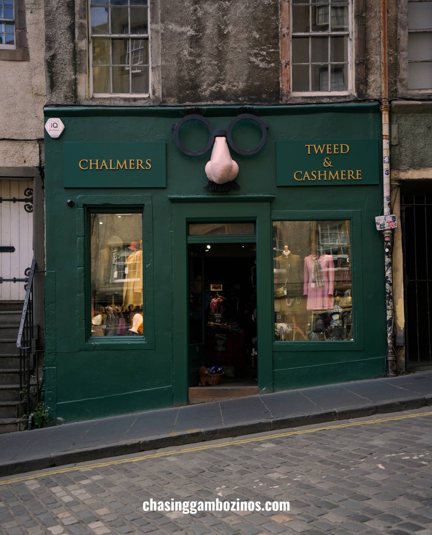 Fachada de uma loja na Old Town de Edimburgo, pintada de verde e com um nariz decorativo.