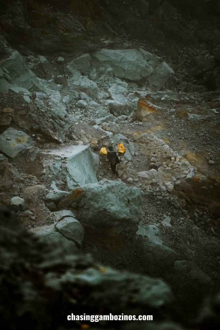 Miner hiking Mount Ijen with baskets full with sulfur blocks.