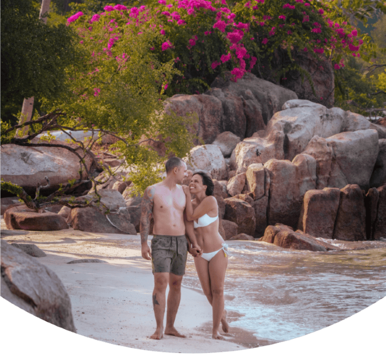 Casal a sorrir enquanto caminha por uma das melhores praias de Koh Tao, como capa para um guia de viagem sobre o que fazer em Koh Tao.